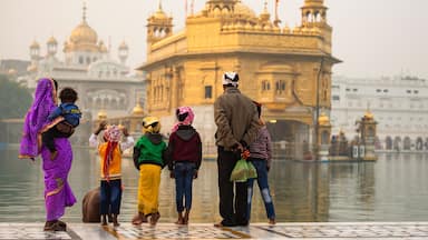 An indian family is admiring the majestic Golden Temple of Amritsar in the state of Punjab, India.