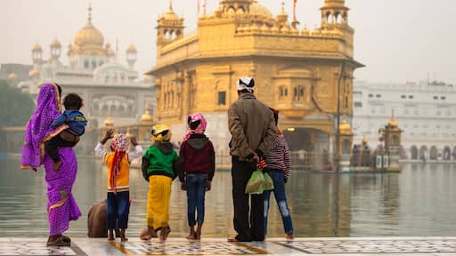 An indian family is admiring the majestic Golden Temple of Amritsar in the state of Punjab, India.