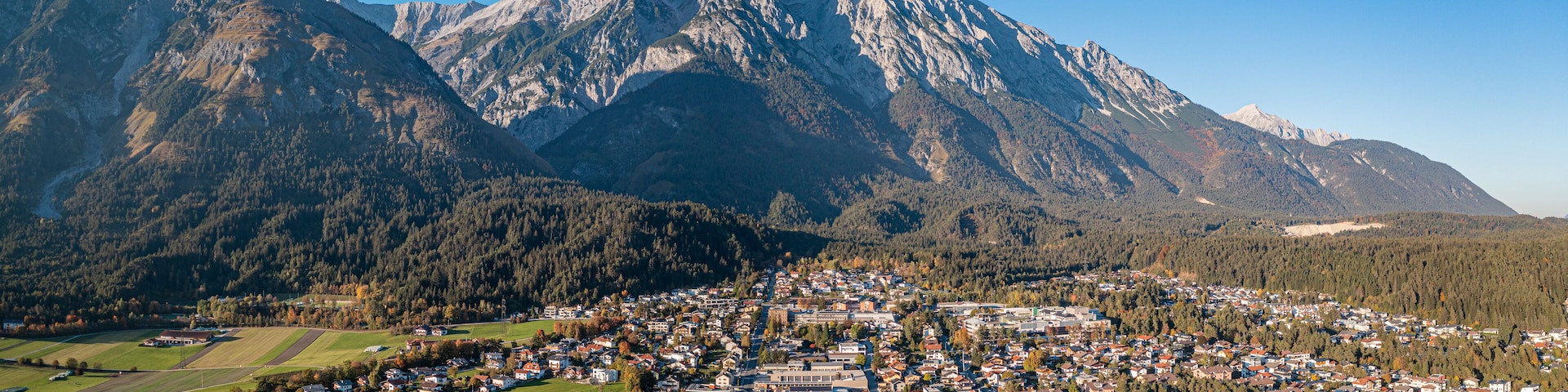 A town nestled between mountains with a clear sky.
