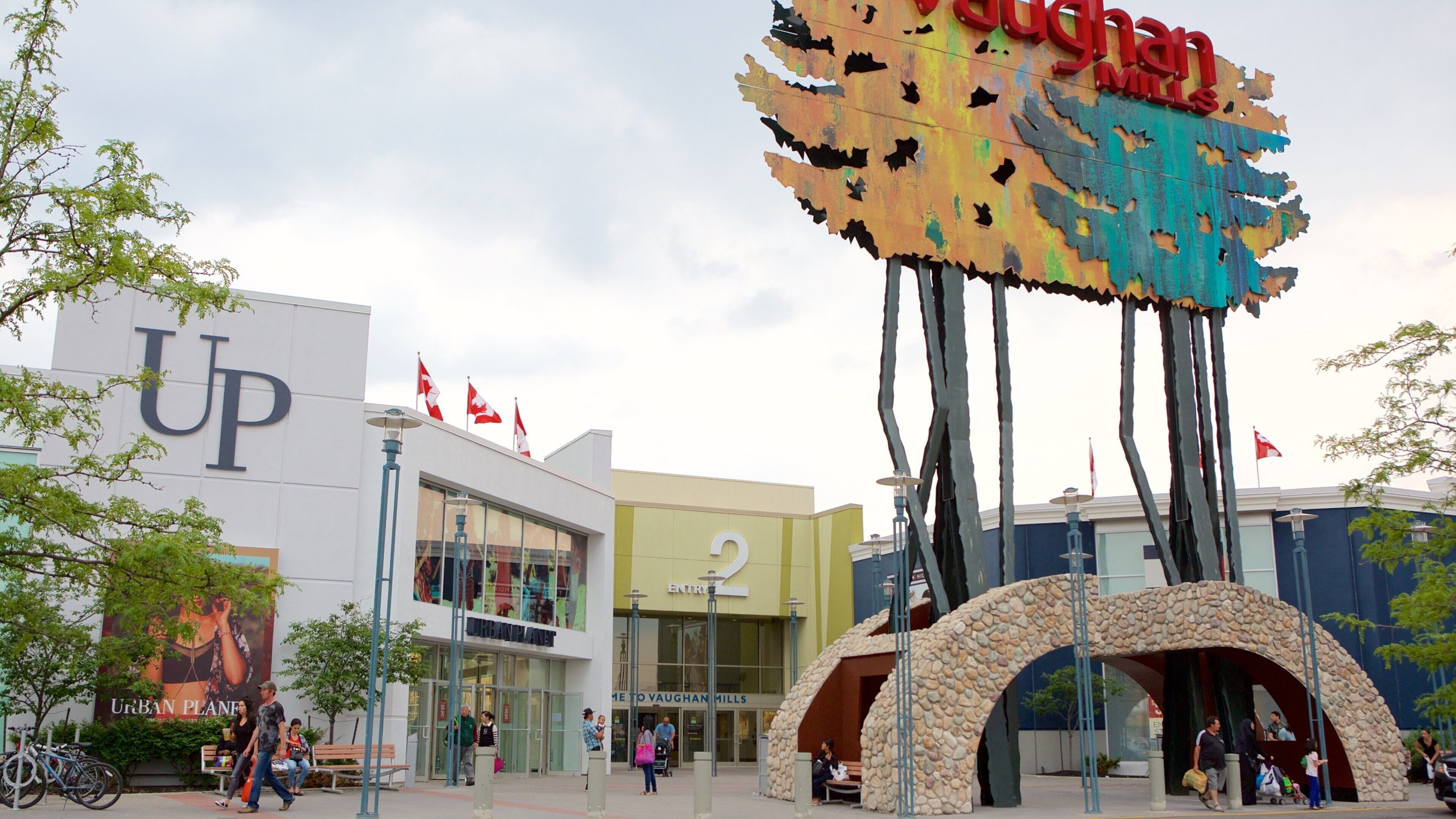 A shopping mall with a large sign reading "Vaughan Mills" and a building with a 'UP' sign.