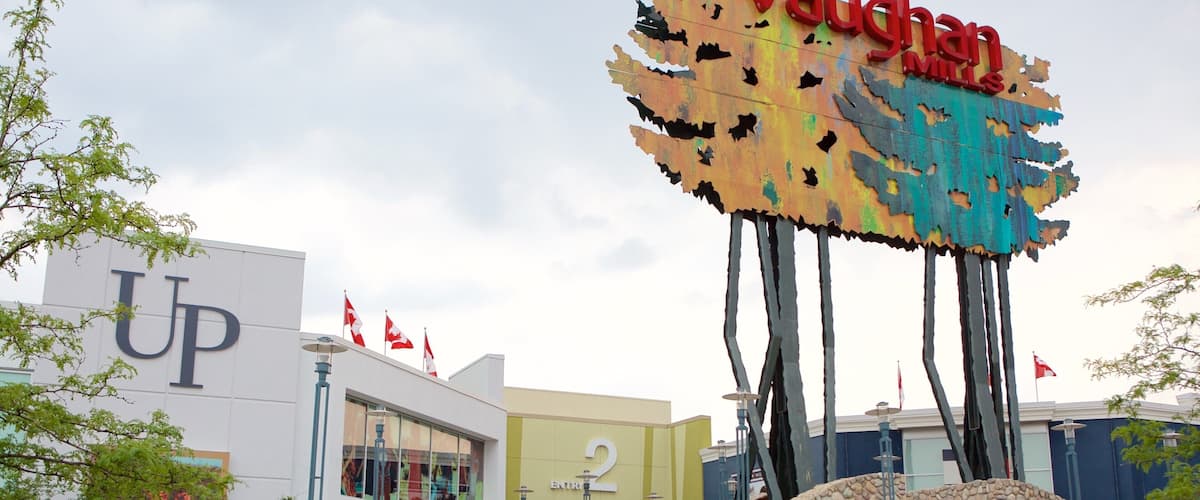A shopping mall with a large sign reading "Vaughan Mills" and a building with a 'UP' sign.