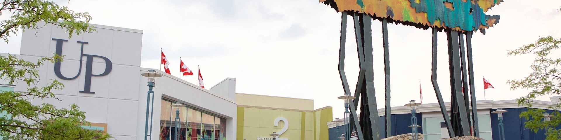 A shopping mall with a large sign reading "Vaughan Mills" and a building with a 'UP' sign.