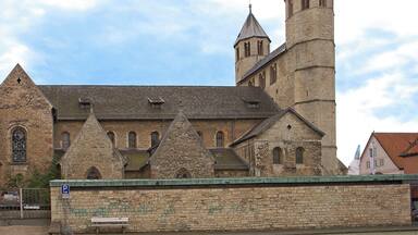 A historic stone building with a prominent tower and arched windows.