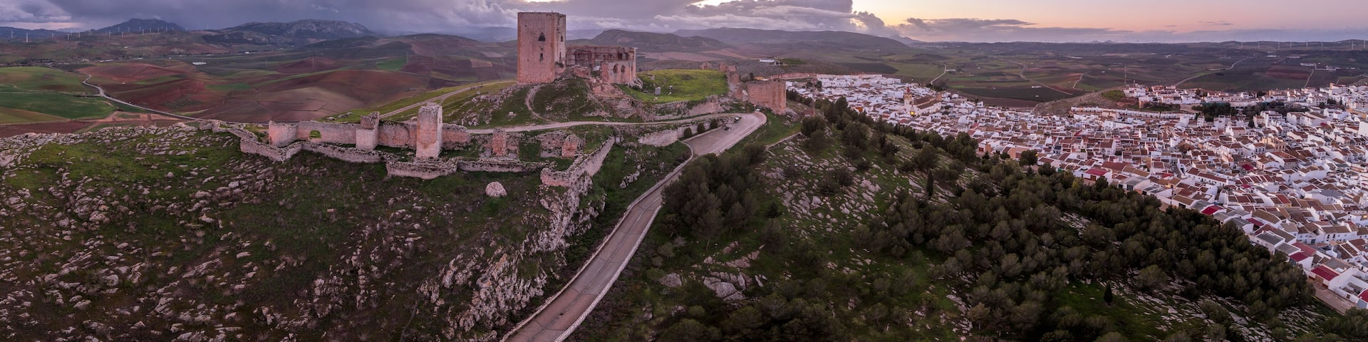 Aerial view of Castillo de la Estrella, Star castle in Teba Spain with large square keep dramatic colorful sunset sky