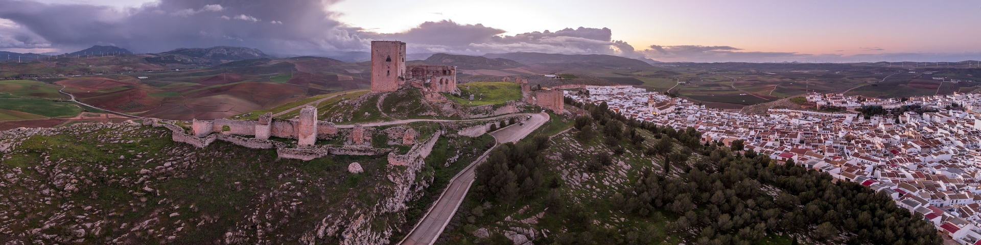 Aerial view of Castillo de la Estrella, Star castle in Teba Spain with large square keep dramatic colorful sunset sky