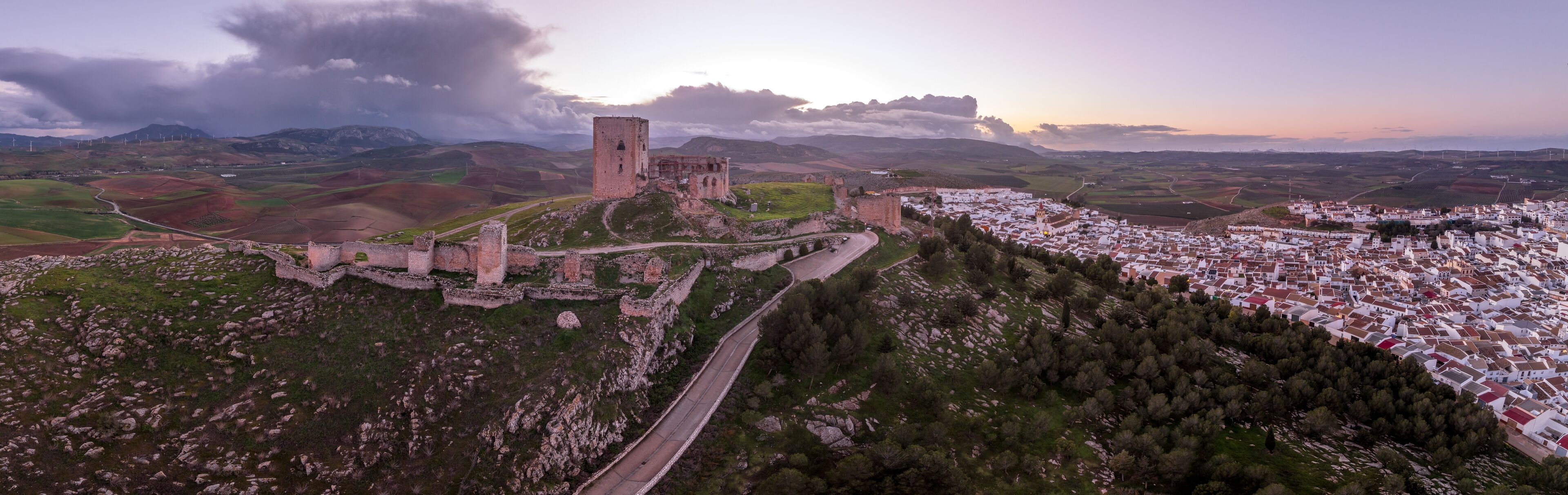 A historic castle on a hill overlooking a village.
