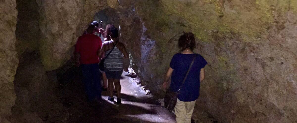 A group of people walking through a narrow cave passage.