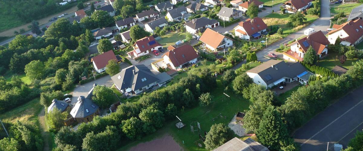 An aerial view of a residential area with houses, roads, and surrounding fields.