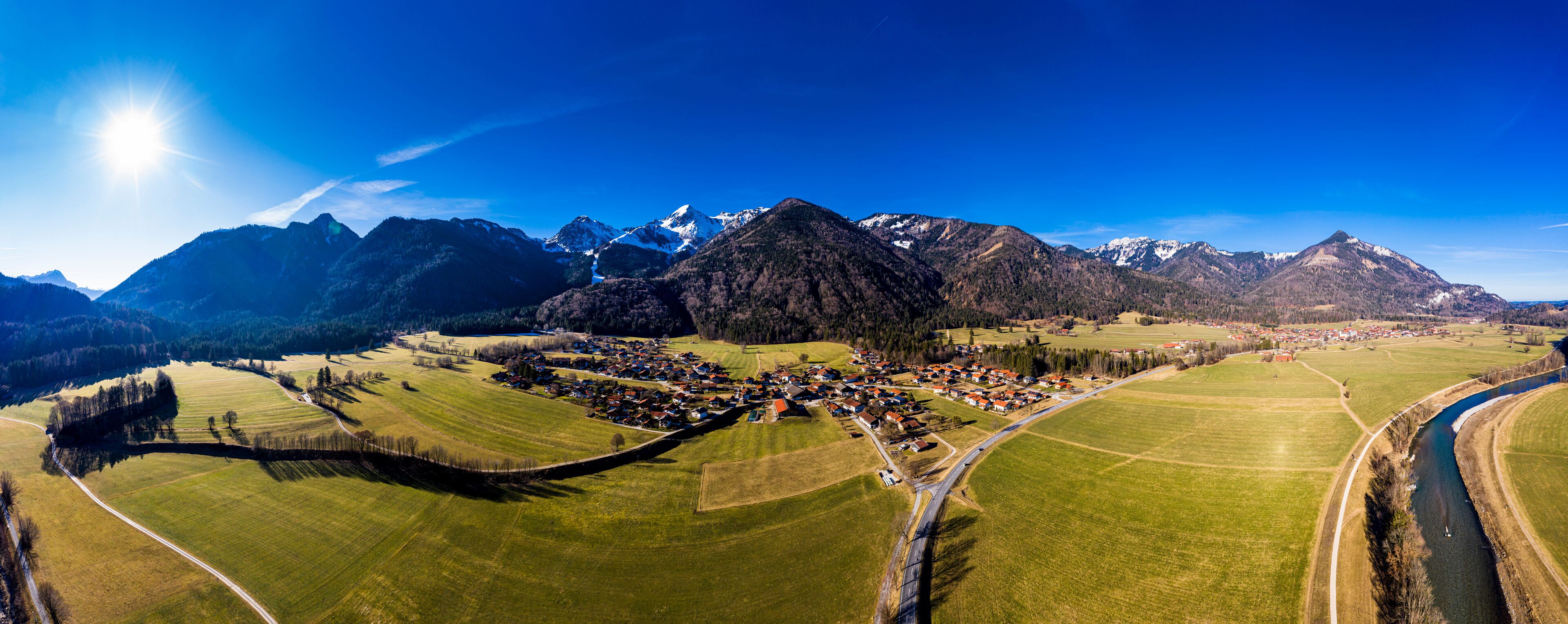 Germany, Bavaria, Schleching, Helicopter panorama of summer sun shining over town in Alpine foothills