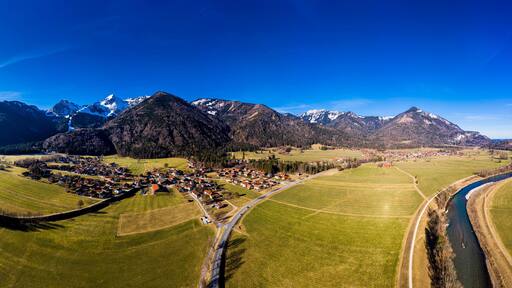Germany, Bavaria, Schleching, Helicopter panorama of summer sun shining over town in Alpine foothills