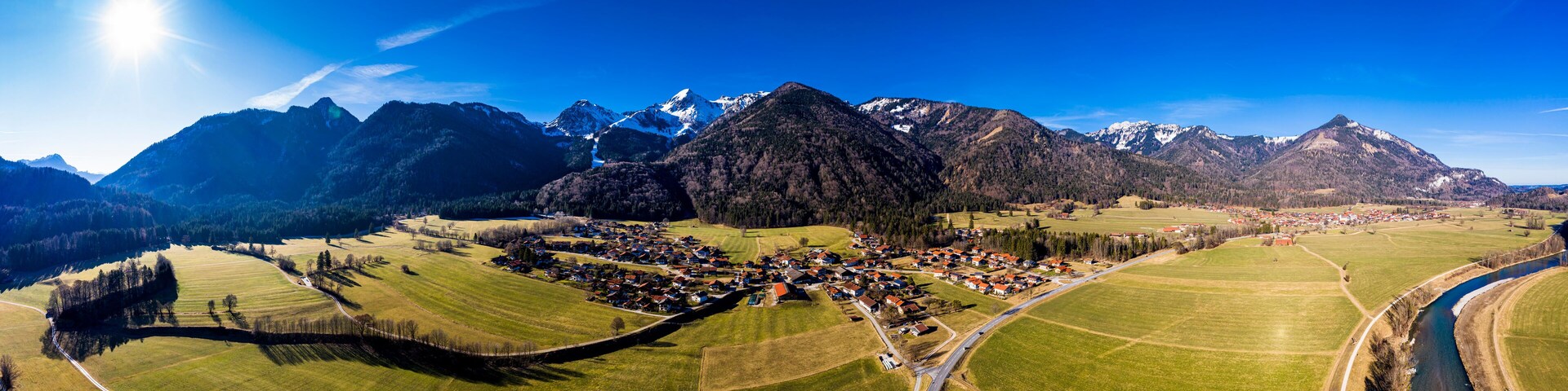 Germany, Bavaria, Schleching, Helicopter panorama of summer sun shining over town in Alpine foothills