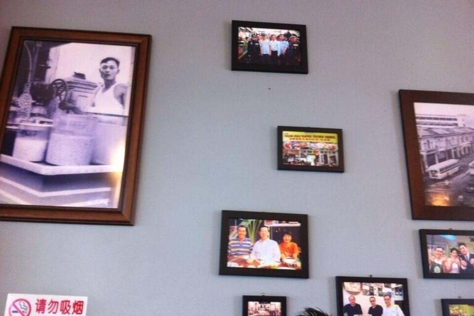A wall with multiple framed photographs and a 'No Smoking' sign.
