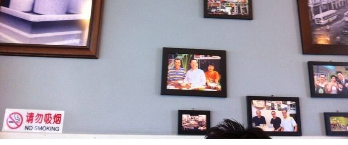 A wall with multiple framed photographs and a 'No Smoking' sign.