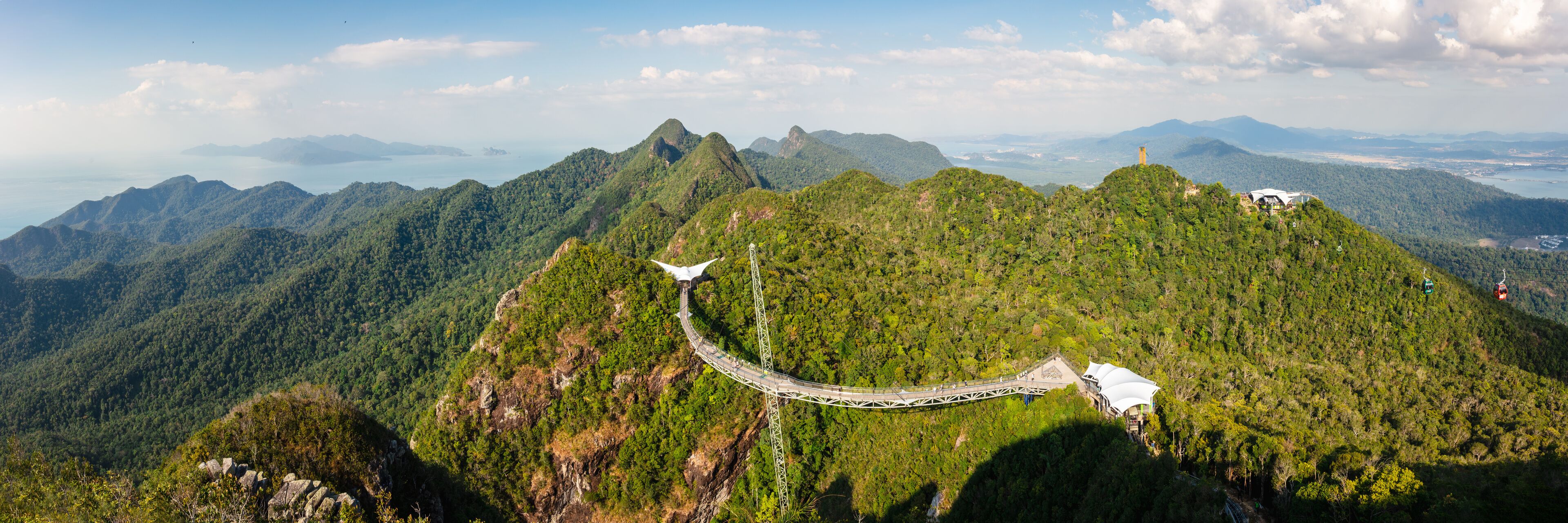 A cable car system winding through a mountainous forest.