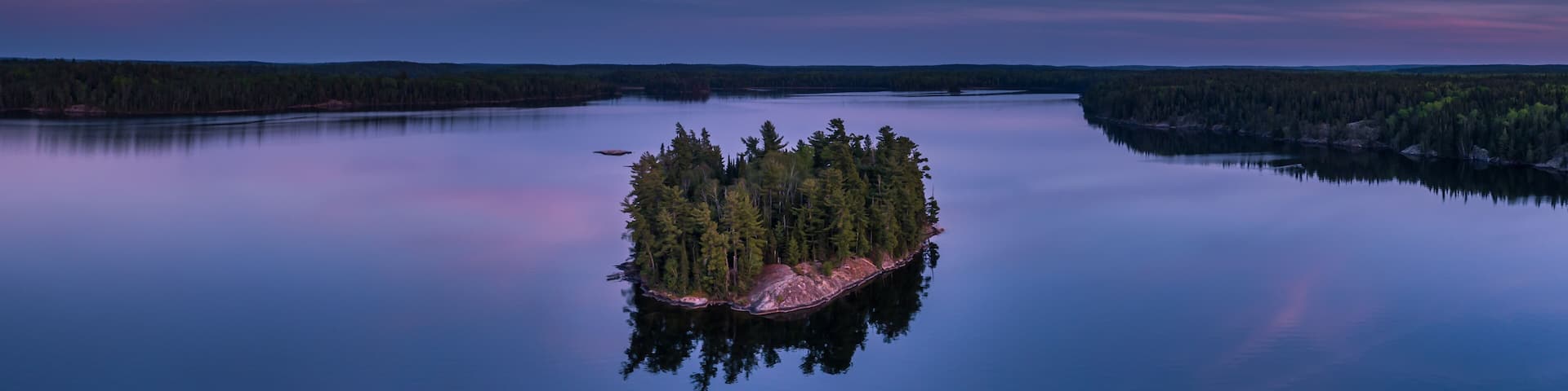 A lonely little island on Eagle Lake at blue hour in Northwest Ontario, Canada.