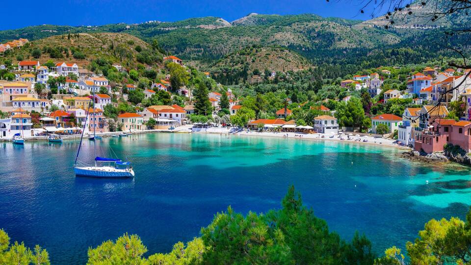 A coastal town with colorful houses, clear turquoise waters, and boats.
