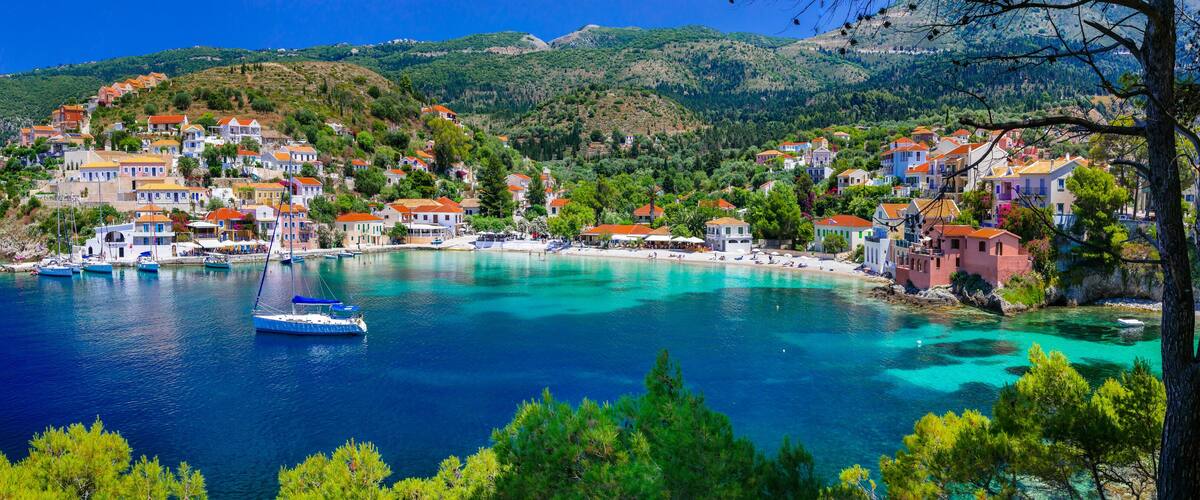 A coastal town with colorful houses, clear turquoise waters, and boats.
