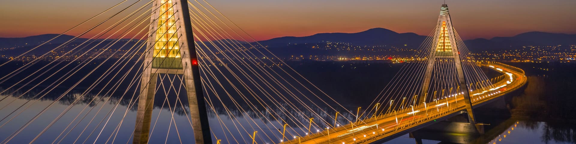 Budapest, Hungary - Aerial view of the illuminated Megyeri Bridge at dusk with clear blue sky