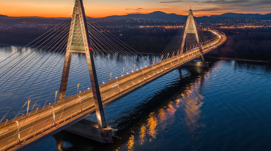 Budapest, Hungary - Aerial view of the beautiful illuminated cable-stayed Megyeri Bridge over River Danube with blue and orange sky at sunset