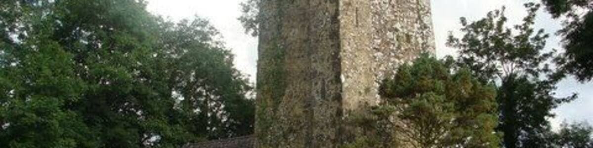 Ein historischer Steinturm mit Friedhof und Grabsteinen.
