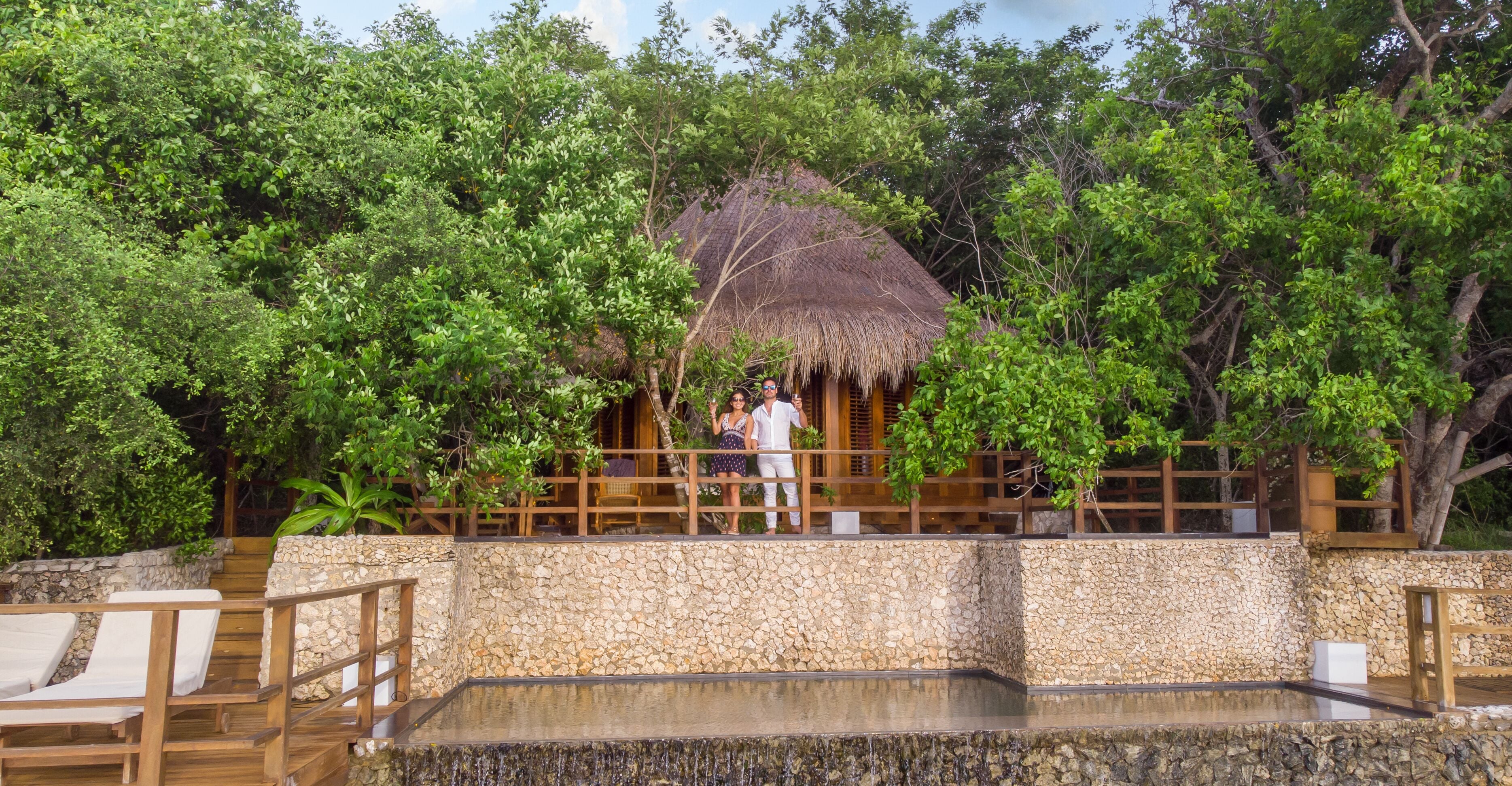 Lovely couple celebrating in a bungalow balcony in the middle if a village in nature.