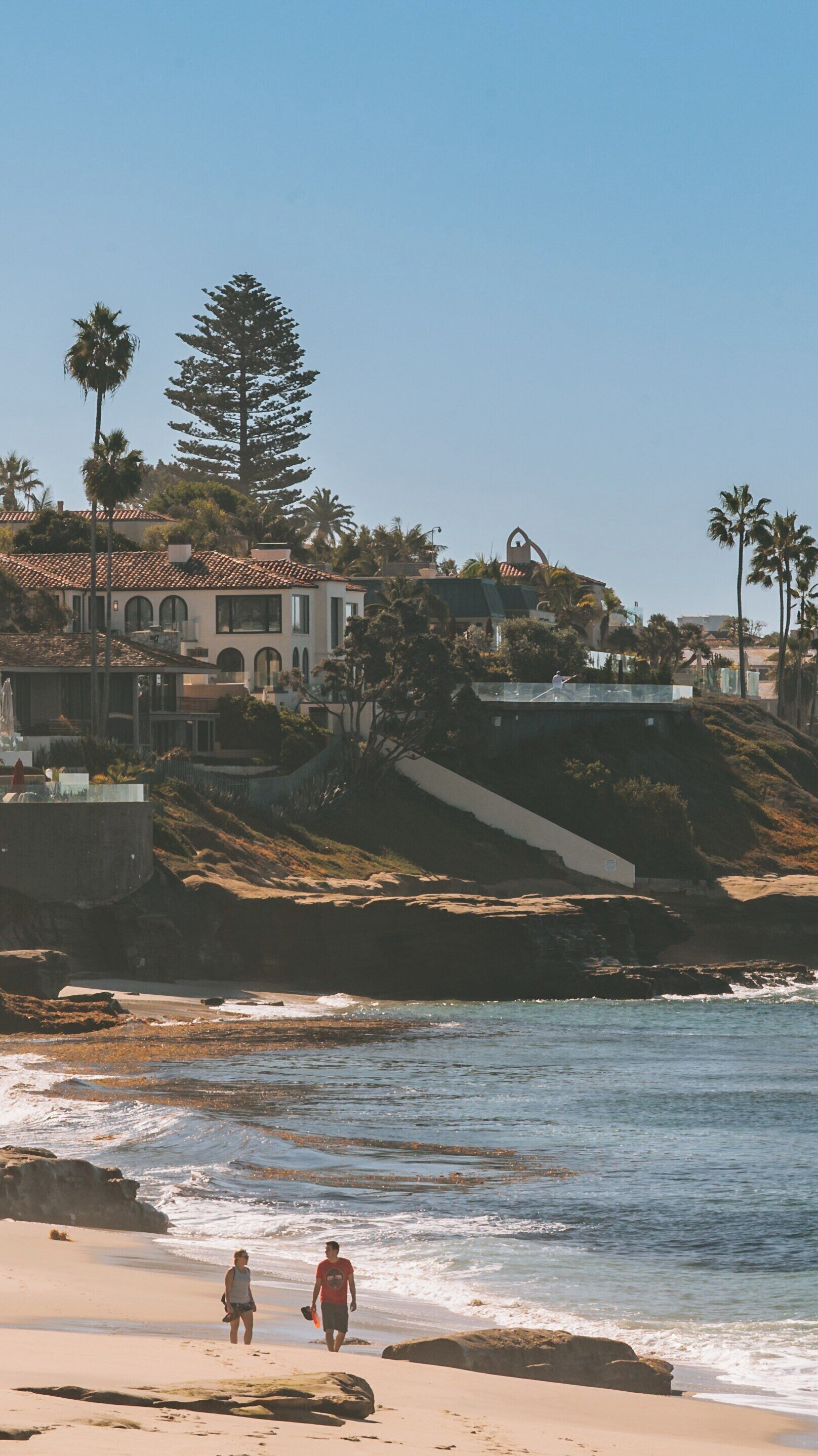 Windansea Beach offers stunning coastal views and relaxation for visitors walking along the shore in La Jolla, California on a sunny day