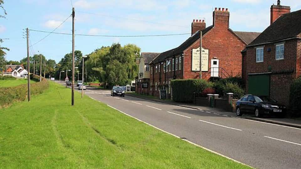 Entering Sibson from the South The road is the A444. Both Sibson pubs are visible here, The Millers in the centre of the picture, the Cock Inn is the white building on the far left.