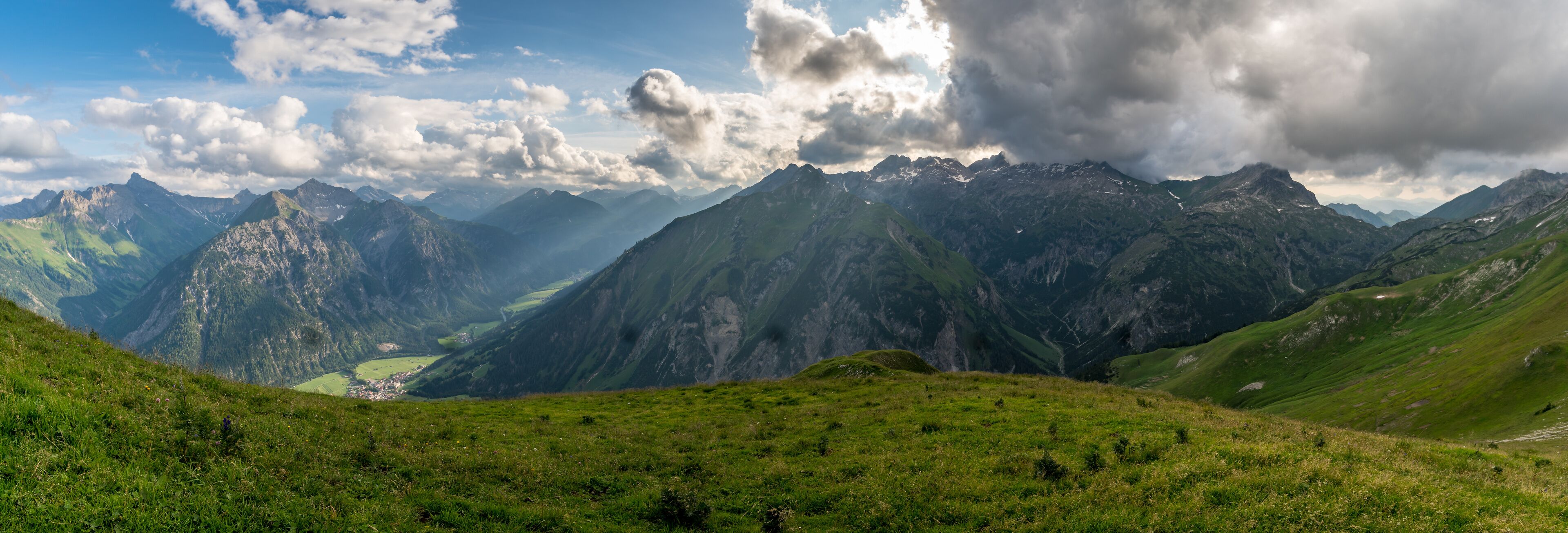 A mountainous landscape with a valley and a small town.