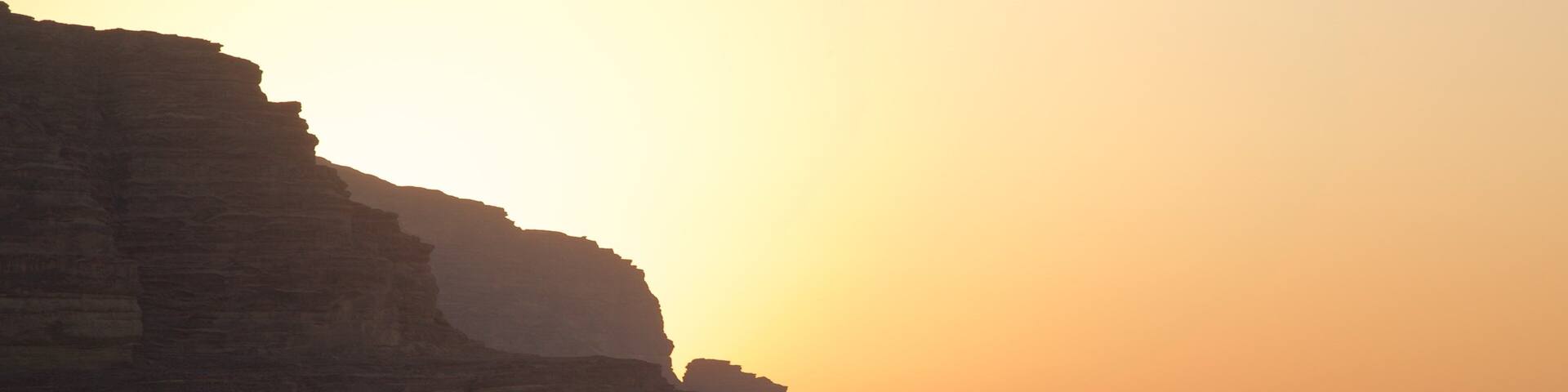 Wadi Rum which includes a sunset, desert views and a gorge or canyon