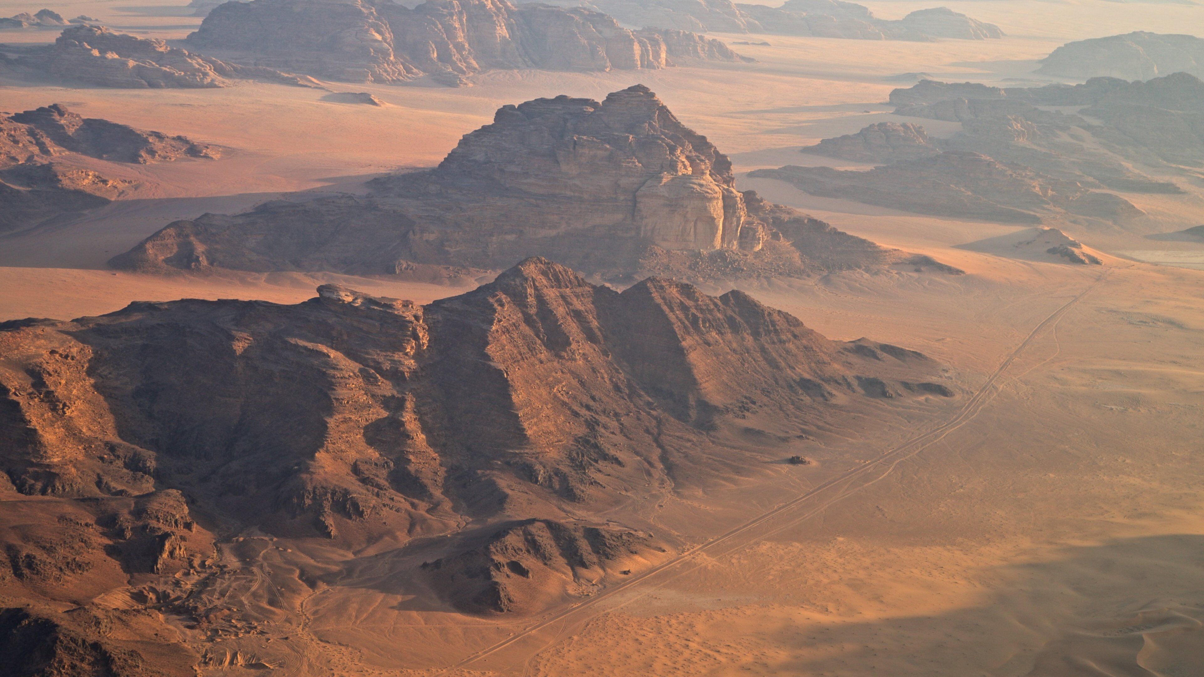 A desert landscape with rocky formations and a winding road.