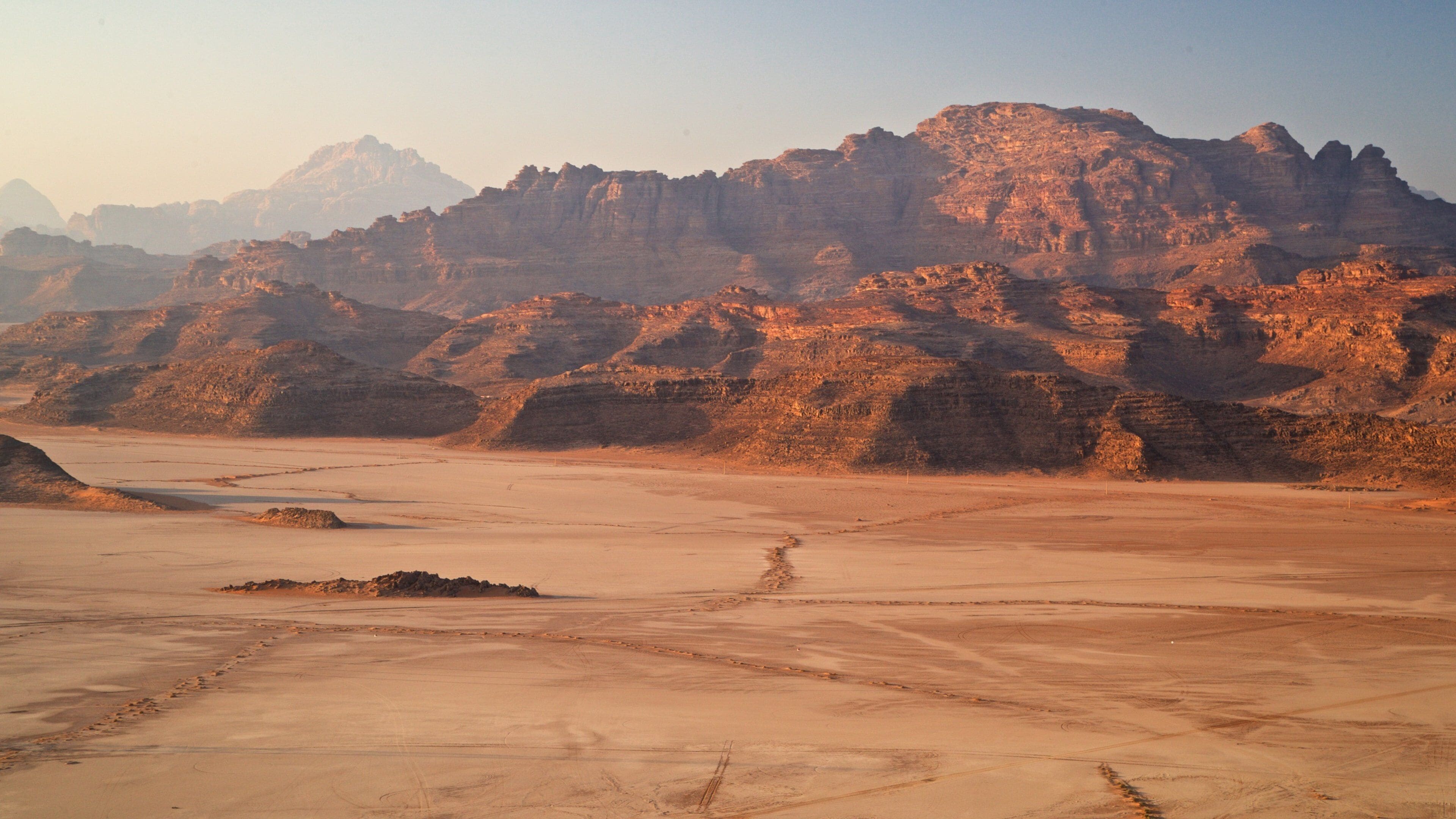 A desert landscape with rocky mountains and a flat terrain.