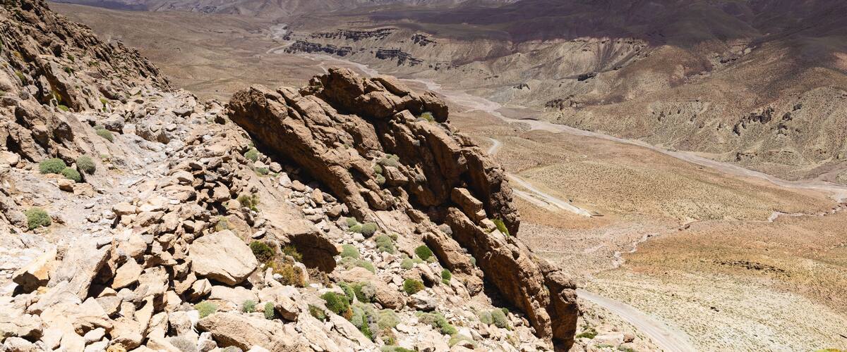 A rugged mountain landscape with rocky outcrops and a winding road.