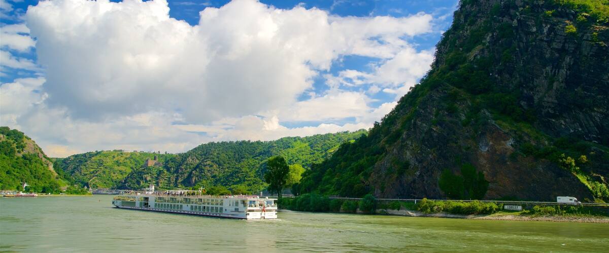 A river with a boat, a bridge, and a mountain.