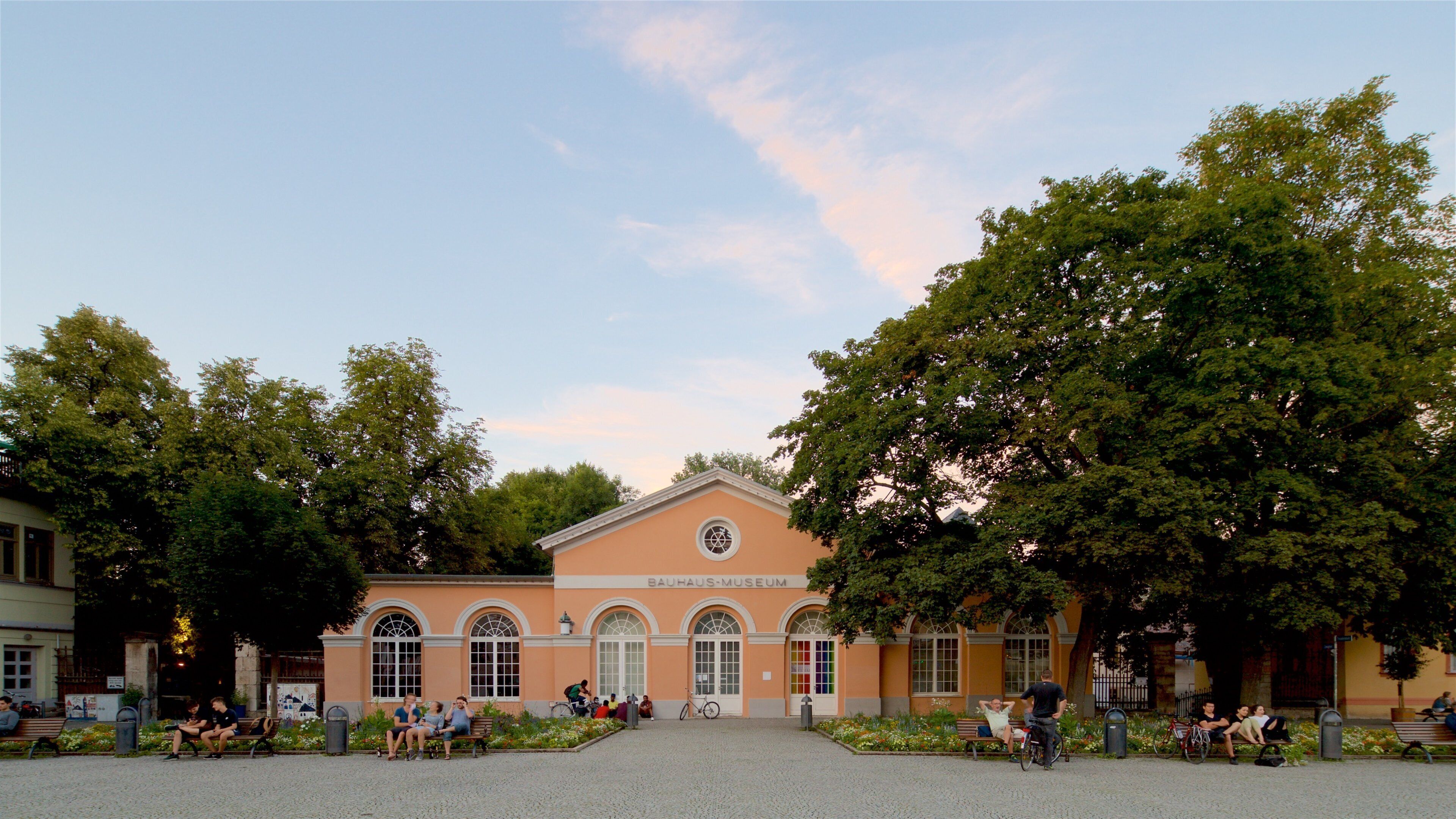 Bauhaus Museum which includes a sunset as well as a small group of people