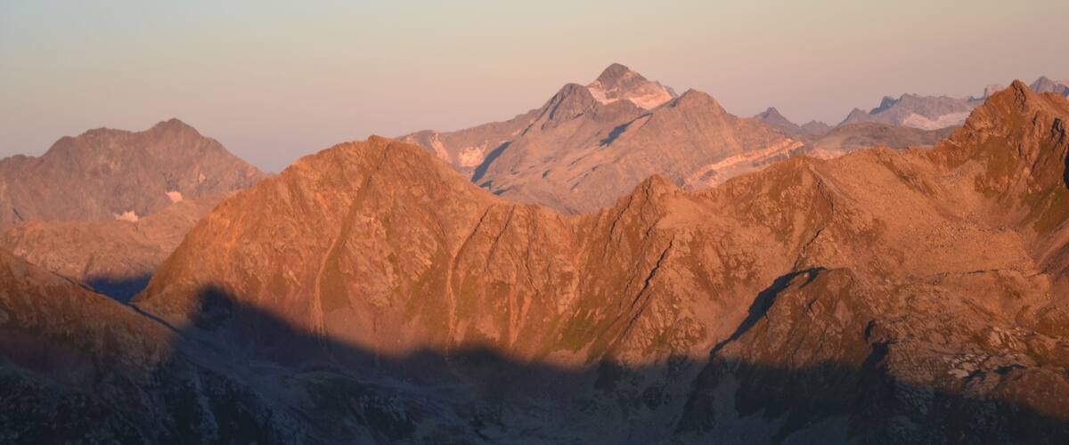 A mountainous landscape with a prominent moon in the sky.