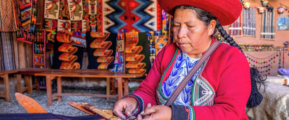 A person weaving colorful textiles.