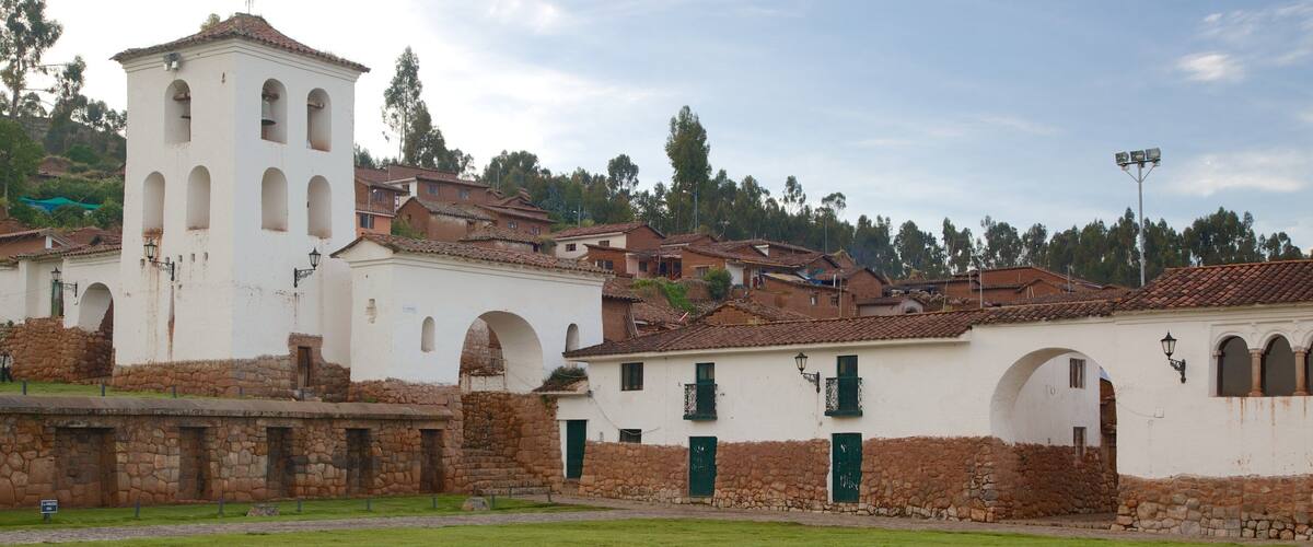 A historic town with white buildings, stone walls, and a bell tower.