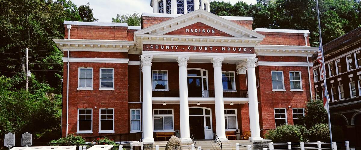 A brick courthouse with a dome and columns, labeled 'Madison County Court House'.