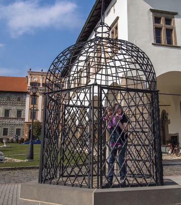 the cage of shame is now open and you can get in!
Staying in the cage was considered as disgrace for the punished and as a warning for the others. Because of this reason, the punishment was often carried out during the fairs when the whole square was full of people. Bystanders usually treated the punished quite bad – calling names, spitting and throwing rotten vegetables or even stones was quite common. The most frequent inhabitants of the cage were women who appeared in the streets of Levoča after the lamps were lit, not accompanied by men.
