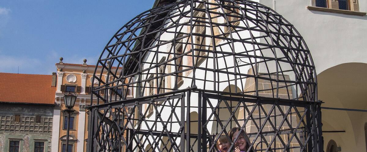 A metal gazebo with a dome structure in an urban setting.