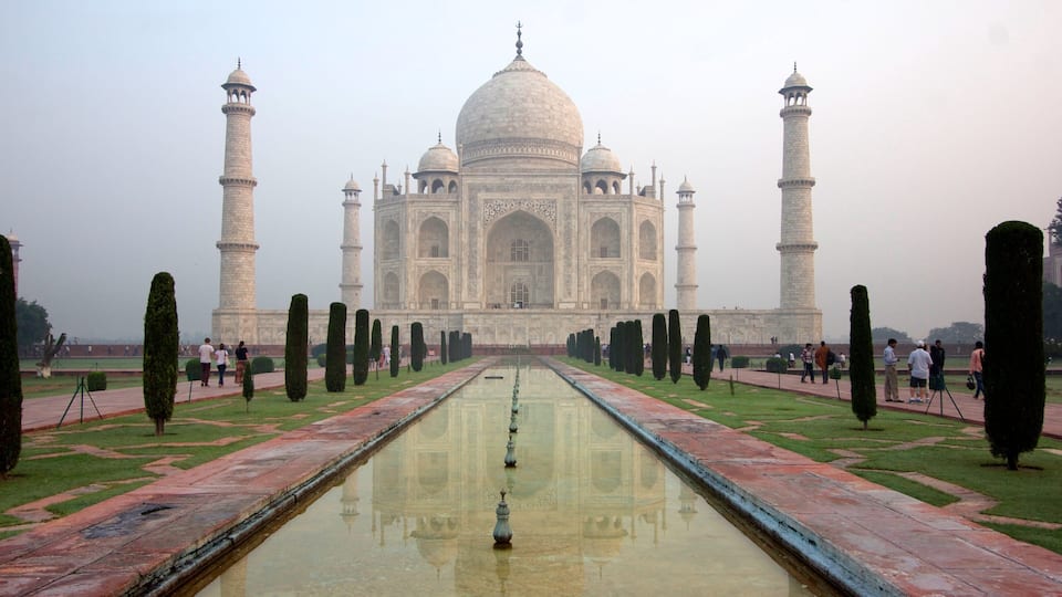 Taj Mahal which includes mist or fog, a fountain and a monument