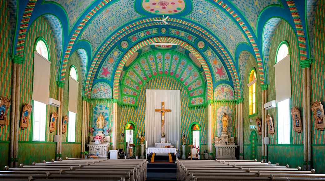 An ornate church interior with colorful mosaics, arched ceilings, and religious statues.