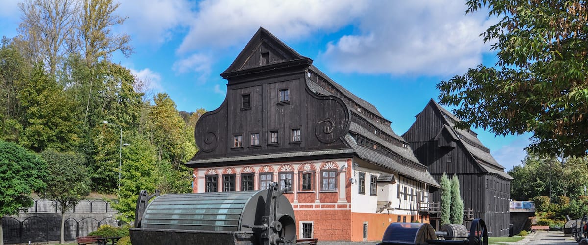 A historic building with a large cannon and a water wheel.