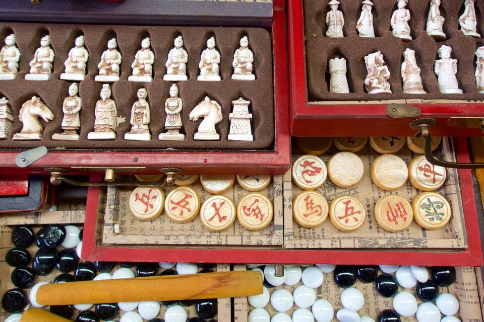 A traditional Chinese chess set with pieces in a wooden box.
