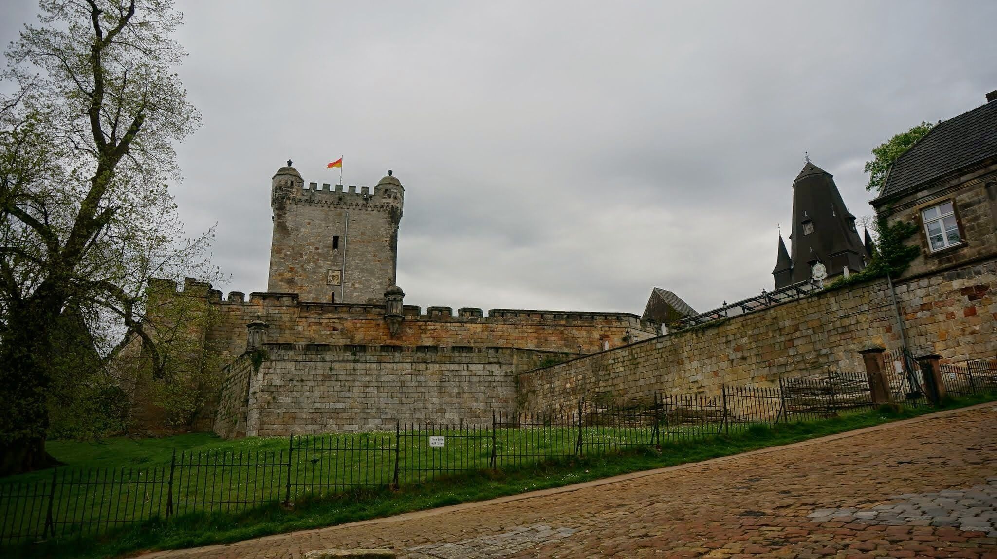 A historic stone castle with a prominent tower and a flag atop.