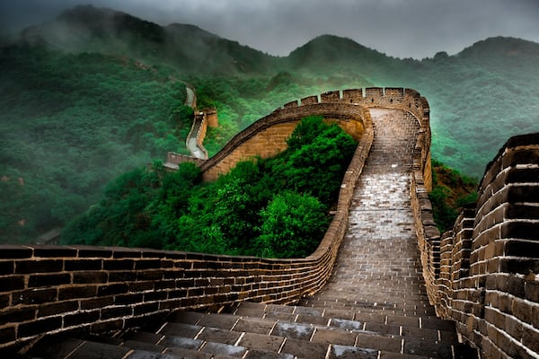 Ein Abschnitt der Chinesischen Mauer schlängelt sich durch eine gebirgige Landschaft.