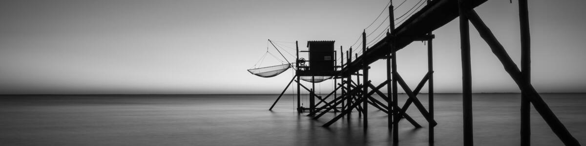 Traditional fishing hut with wooden walkway on the Atlantic coast at sunset, Aytre, France. black and white ppanorama shot