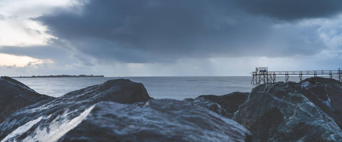 A rocky shoreline with a pier extending into the water.