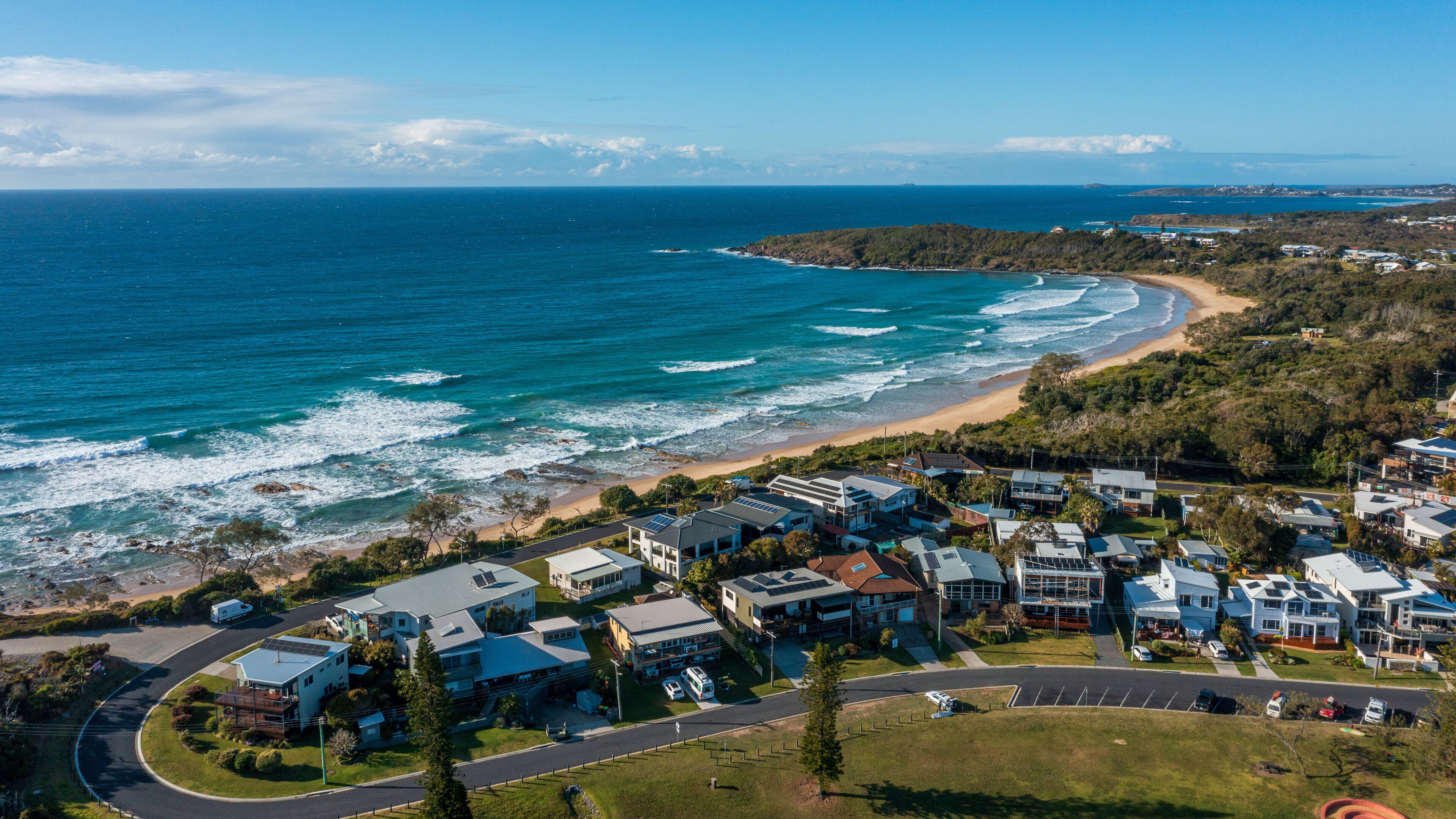 A coastal residential area with houses, a beach, and the ocean.