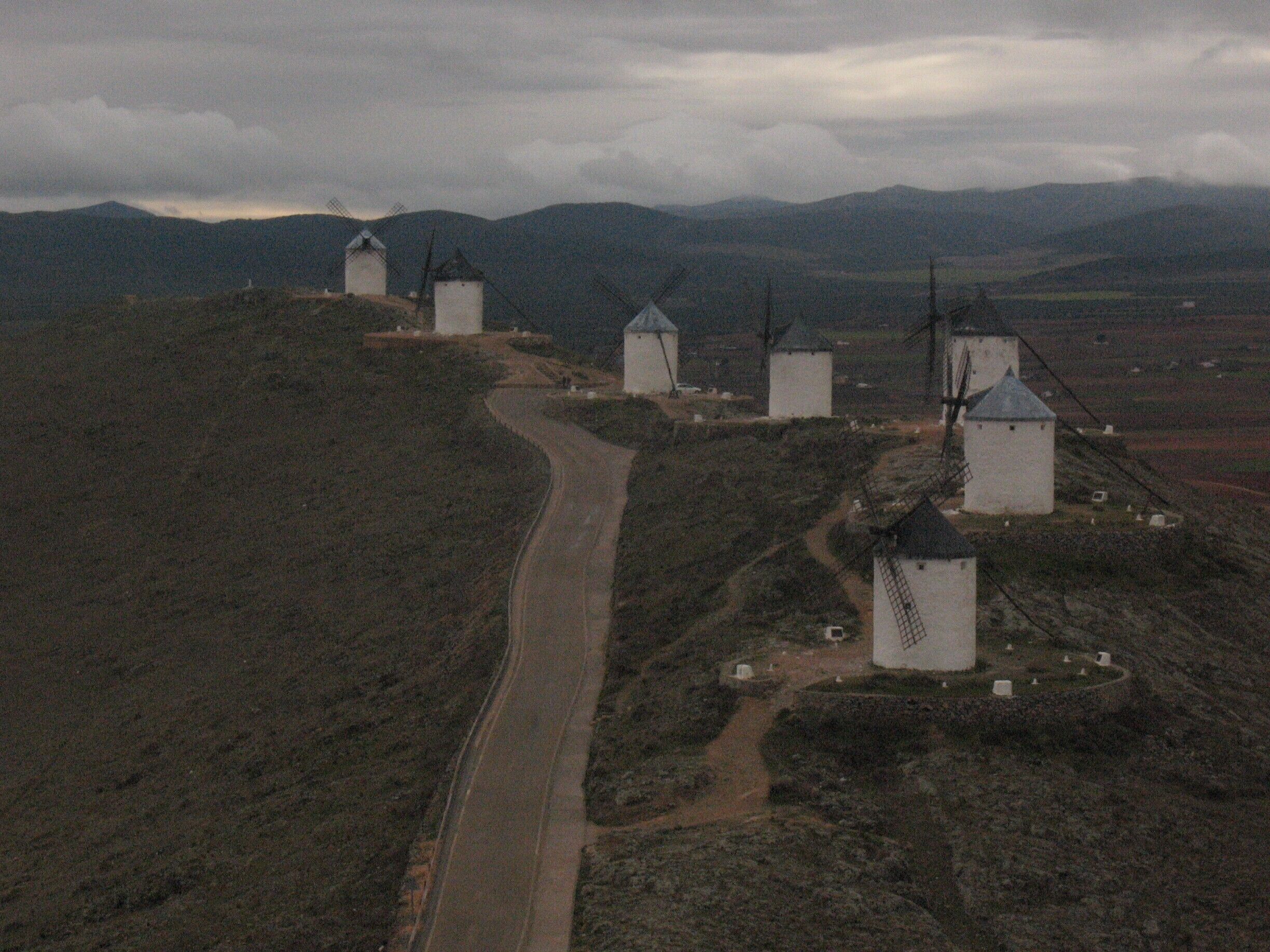I believe these windmills were constructed after Don Quixote was published, inspired by the windmills that inspired Cervantes.  There's also a castle along this route that you can explore.

You can reach Consuegra and Molino Rucio via a bus from Toledo (at least you could in 2011)